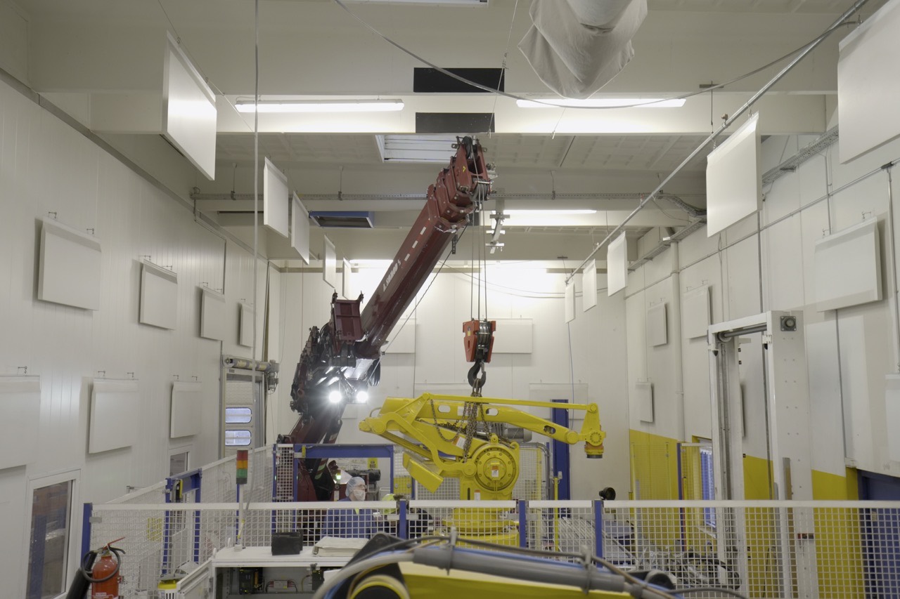 A. Sømod løfter tungt gods med kran i en industrihal